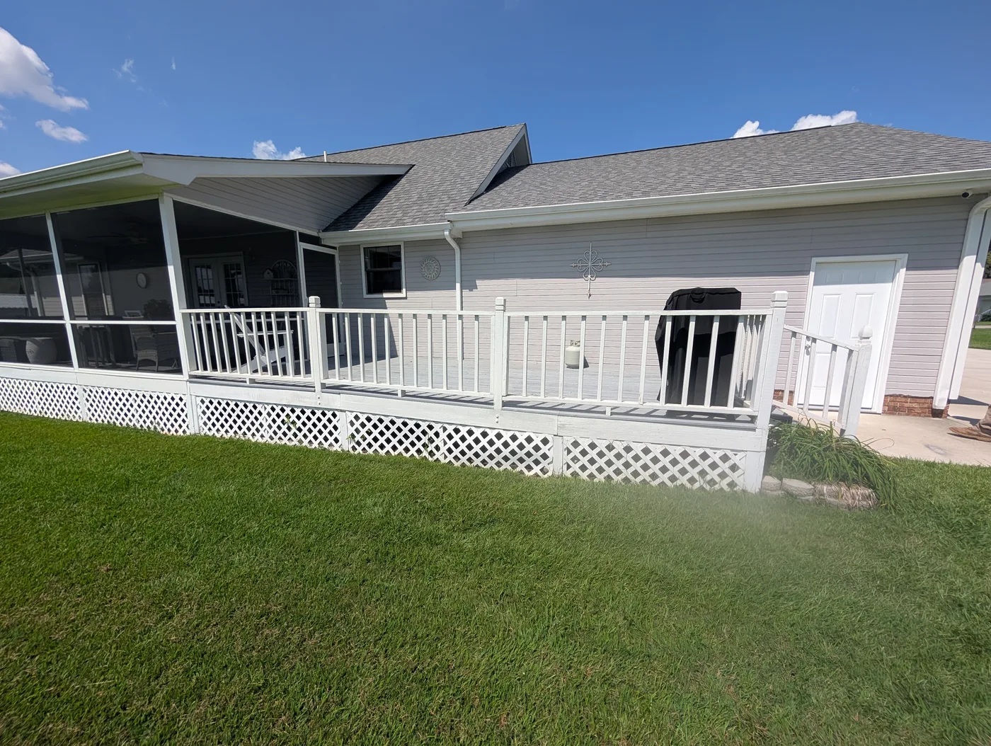 Finished light-colored deck, railings, and lattice beside a screened porch, from a Frye Inc. project