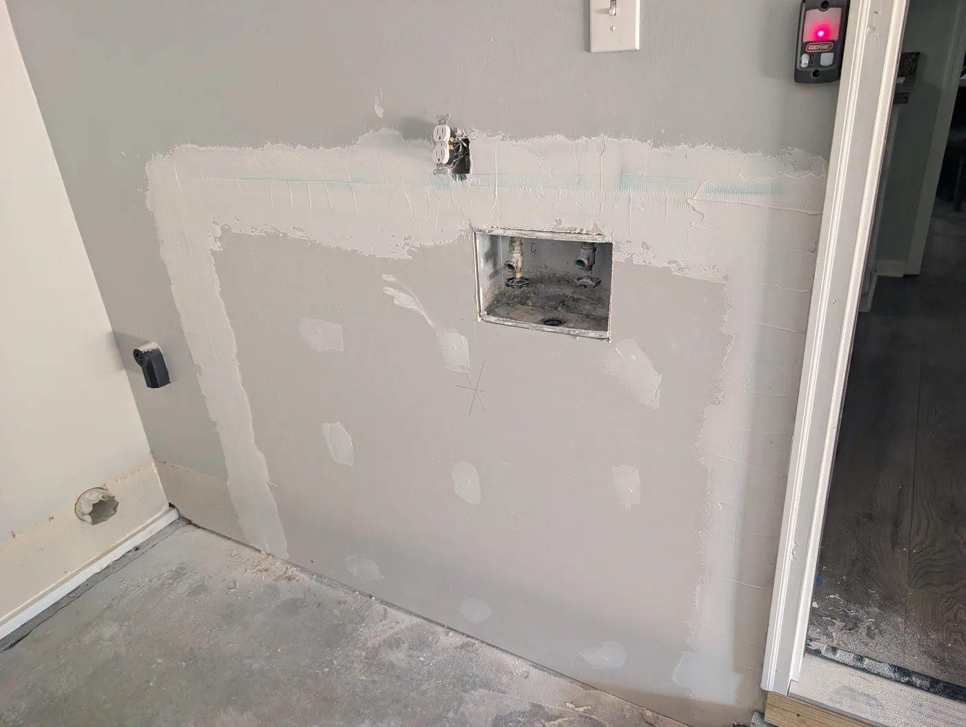 Laundry-room drywall repair in progress by Frye Inc., before final finishing