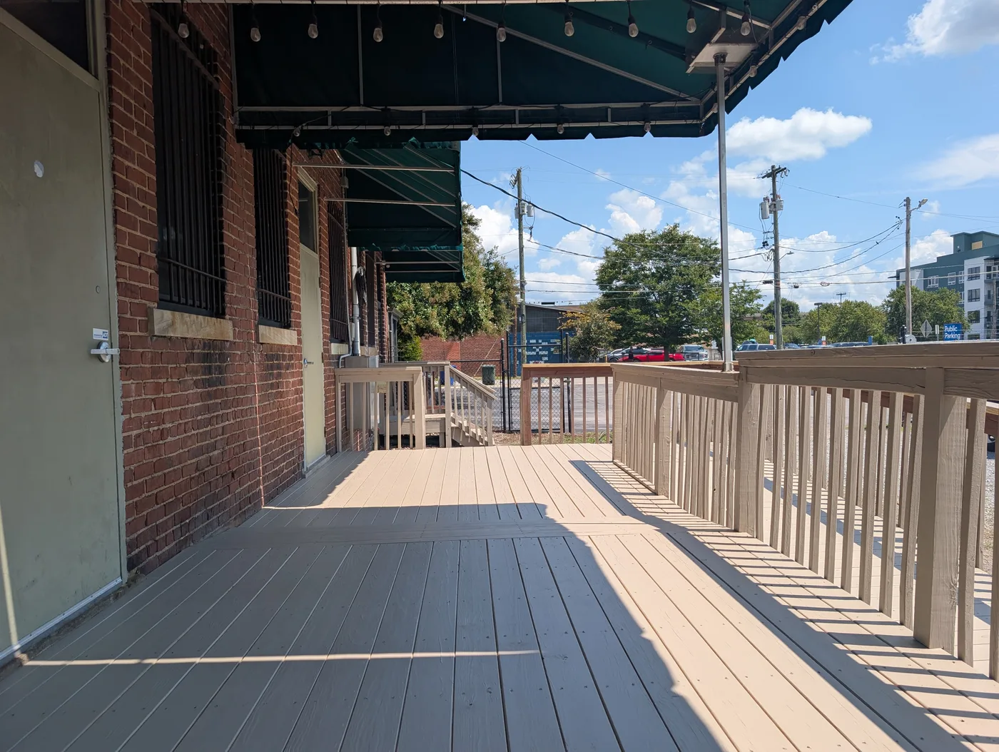 Gray finished deck boards and railings beside a brick exterior, from a Frye Inc. project